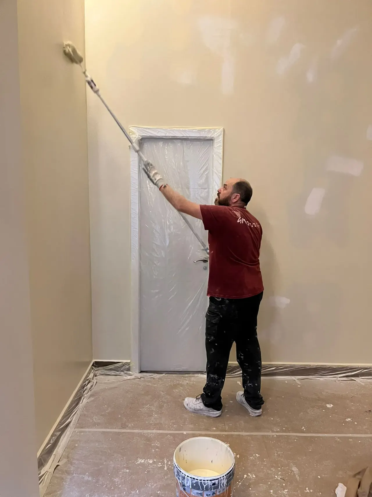 F. Rubén Pérez pintando con rodillo una pared interior